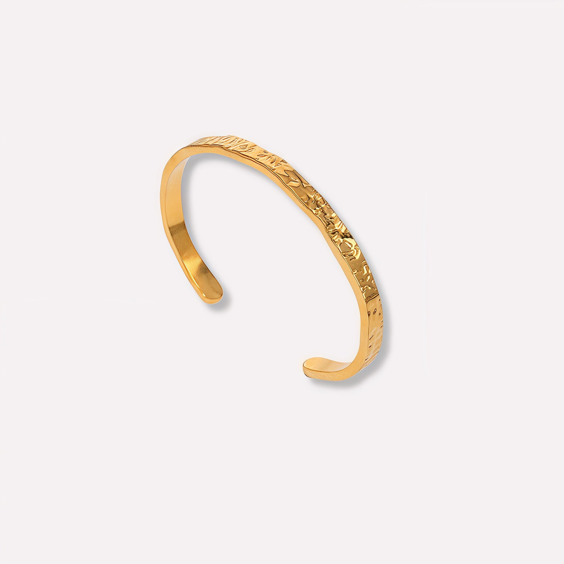 Gold bracelet on a light gray background